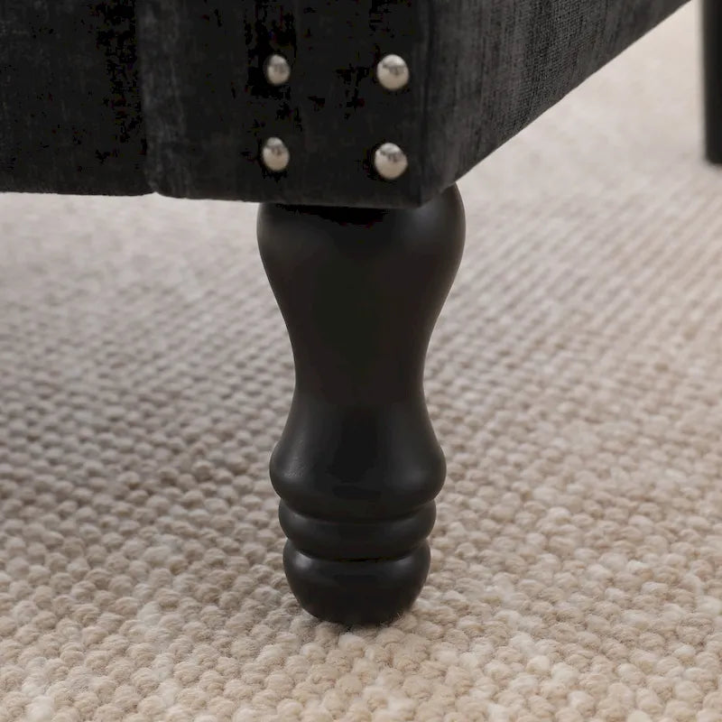 Poltrona moderna imbottita con borchie e gambe in legno