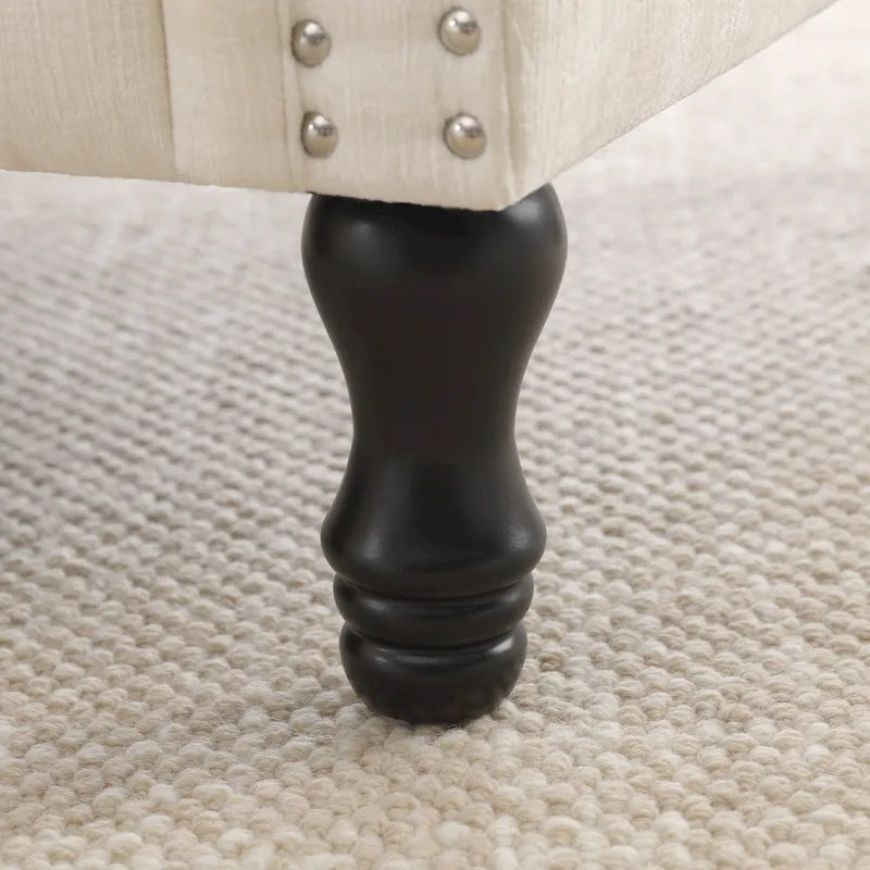 Poltrona moderna imbottita con borchie e gambe in legno